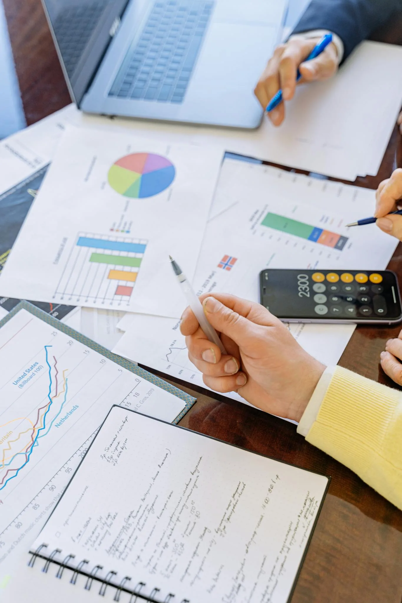 A close-up of businesspeople analyzing financial data and charts during a meeting. no credit check loans